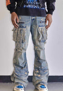 A person wearing heavily distressed light-wash blue denim cargo pants with multiple flap pockets, ripped details, and frayed edges, paired with a black graphic hoodie and white sneakers.