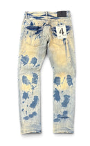 Light wash blue jeans with a distressed bleach-splatter pattern in dark blue, showing the back pockets and a hangtag with the number 4. By Fresh N Fitted.