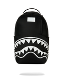 A black backpack featuring a bold white shark mouth graphic with sharp teeth across the lower front, shown on a clean white background. By Fresh N Fitted