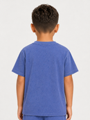 A child viewed from the back wearing a short-sleeve crew-neck t-shirt in a heathered medium blue color, set against a plain light gray studio background.