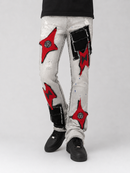 A person wearing light gray distressed denim jeans with large red and black patchwork details, shown from the waist down against a light gray studio background.