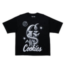 A black short-sleeve t-shirt with a large silver and white graphic on the front featuring the text 'Cookies' and a circular 'C' logo, displayed flat against a white background. By Fresh N Fitted.