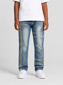 A person wearing light blue distressed denim jeans with decorative yellow thread detailing down the sides and on the upper thighs, paired with a white t-shirt and white sneakers, against a light gray studio background.