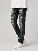 Distressed black denim jeans with a faded gray wash and ripped details, shown on a model wearing a white t-shirt and white sneakers against a light gray studio background.