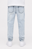 Rear view of a person wearing light-wash blue jeans with a white t-shirt and white sneakers, shown against a plain white studio background.