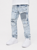 Light blue acid-wash distressed jeans with ripped details and striped patchwork on the thighs, shown on a model wearing a white t-shirt and white sneakers against a white studio background.