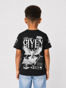 A child model shown from the back wearing a black Givenchy t-shirt with a large white graphic print on the back, paired with light blue jeans, against a light gray studio background.