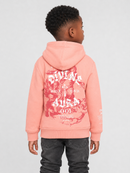 A child model shown from the back wearing a coral pink hoodie with a large red and white graphic print on the back, paired with dark gray jeans, against a light gray studio background.