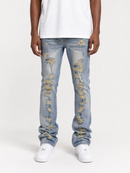 A person wearing light-wash blue distressed jeans with ripped details showing tan underneath, paired with a white t-shirt and white sneakers, photographed against a plain light gray studio background.
