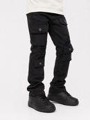 Black cargo pants with multiple flap pockets and button details, shown on a model from the waist down wearing a cream t-shirt and black sneakers against a white studio background