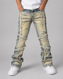 A person wearing heavily distressed and ripped light-wash blue denim jeans with frayed trim details, styled with a white t-shirt and white sneakers against a neutral gray studio background.