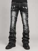 Distressed black denim jeans with heavy ripped detailing and frayed edges, shown on a model from the waist down against a light gray studio background.