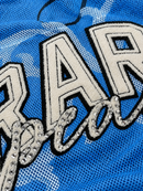 Close-up of a blue mesh garment featuring a large embroidered letter 'A' with silver rhinestone trim and a matching cursive script below, outlined in black. By Fresh N Fitted.