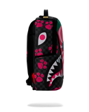 A sprayground backpack available at fresh n fitted featuring a black and dark gray checkerboard shark face design with hot pink paw prints, white eyes, and a mouth with white and pink teeth, shown against a plain white background.