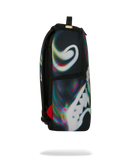 A black sprayground backpack featuring a large white shark face graphic and an iridescent holographic swirl pattern on the front, shown against a plain white background.