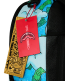 Close-up of a sprayground backpack with a light blue graffiti-style print, black mesh side pockets, and two attached tags: a bright red Shark Attack tag with the brand name SPRAGROUND and a gold/yellow paper tag with black graphics.