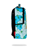 A sprayground backpack featuring a vibrant cartoon-style print of white clouds, green dollar bills, and a yellow sun on a bright blue background, with black straps and trim.