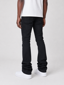 A person shown from the back wearing black slim-fit jeans, a white t-shirt, and white sneakers against a light gray studio background.