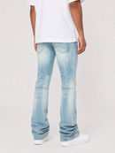 A person shown from the back wearing light-wash blue jeans, a white t-shirt, and white sneakers against a plain light gray studio background.