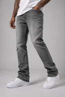 A person wearing slim-fit gray washed denim jeans with a white t-shirt and white sneakers, shown from the waist down against a light gray studio background.