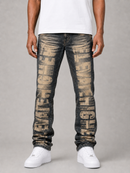 A model from the waist down wearing dark gray distressed jeans with large beige 'GAYECHER' text printed vertically down the front of both legs, styled with a white t-shirt and white sneakers against a gray studio background.