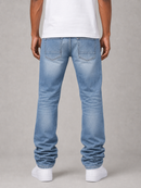 Rear view of a person wearing light blue straight-leg jeans, a white t-shirt, and white sneakers against a neutral gray studio background.