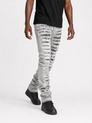 A person wearing distressed light gray jeans with heavy ripped detailing, a black t-shirt, and black sneakers, shown from the waist down against a plain light gray studio background.